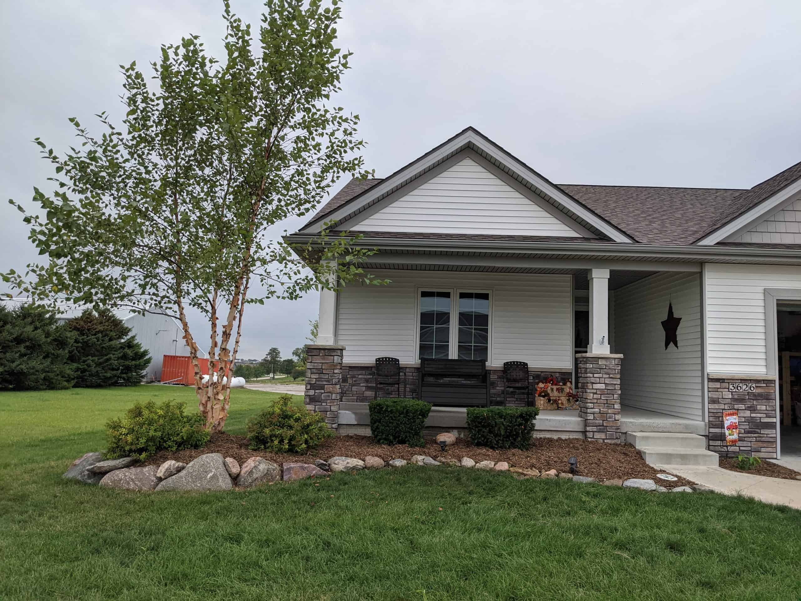 a beautiful concrete porch with outdoor seating in front of a new construction home